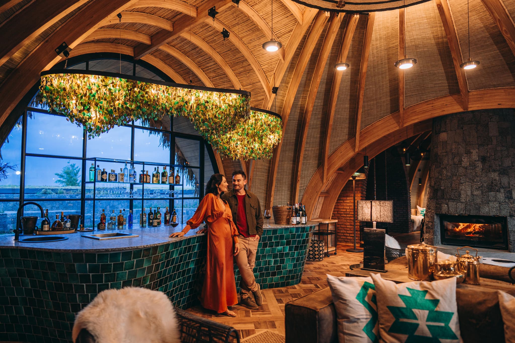 Emerald-tiled bar under sweeping timber arches at Bisate Lodge